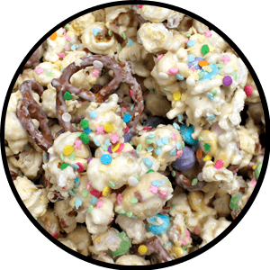 white popcorn and pretzels covered in pastel sprinkles and m and m's 