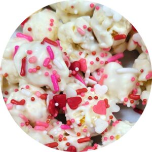 white popcorn with white, pink, and red sprinkles.  and tiny candy hearts.